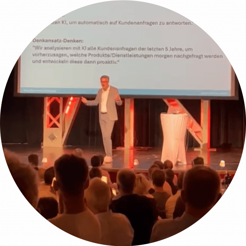 Bernd Rudmann bei einem KI-Vortrag auf der Bühne stehend