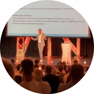 Bernd Rudmann bei einem KI-Vortrag auf der Bühne stehend